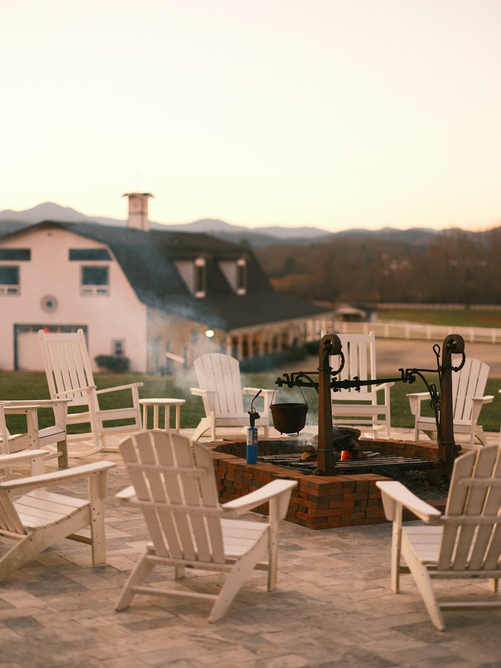 a fire pit surrounded by white lawn chairs