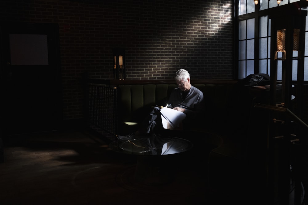 a man sitting on a couch in a dark room