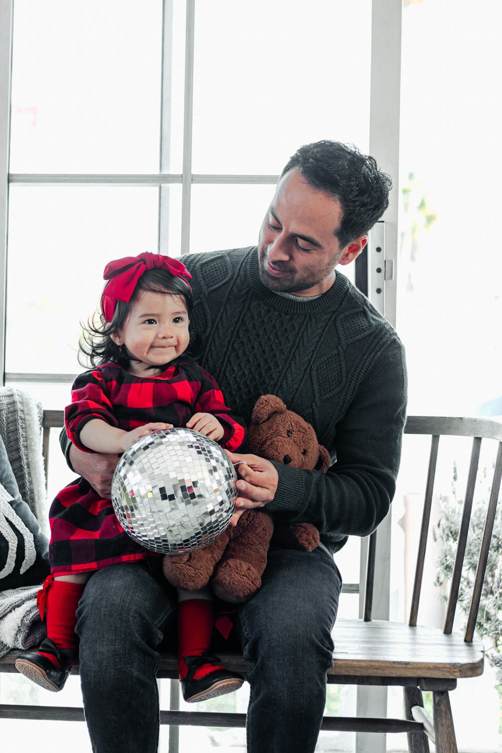 a man sitting on a bench holding a little girl