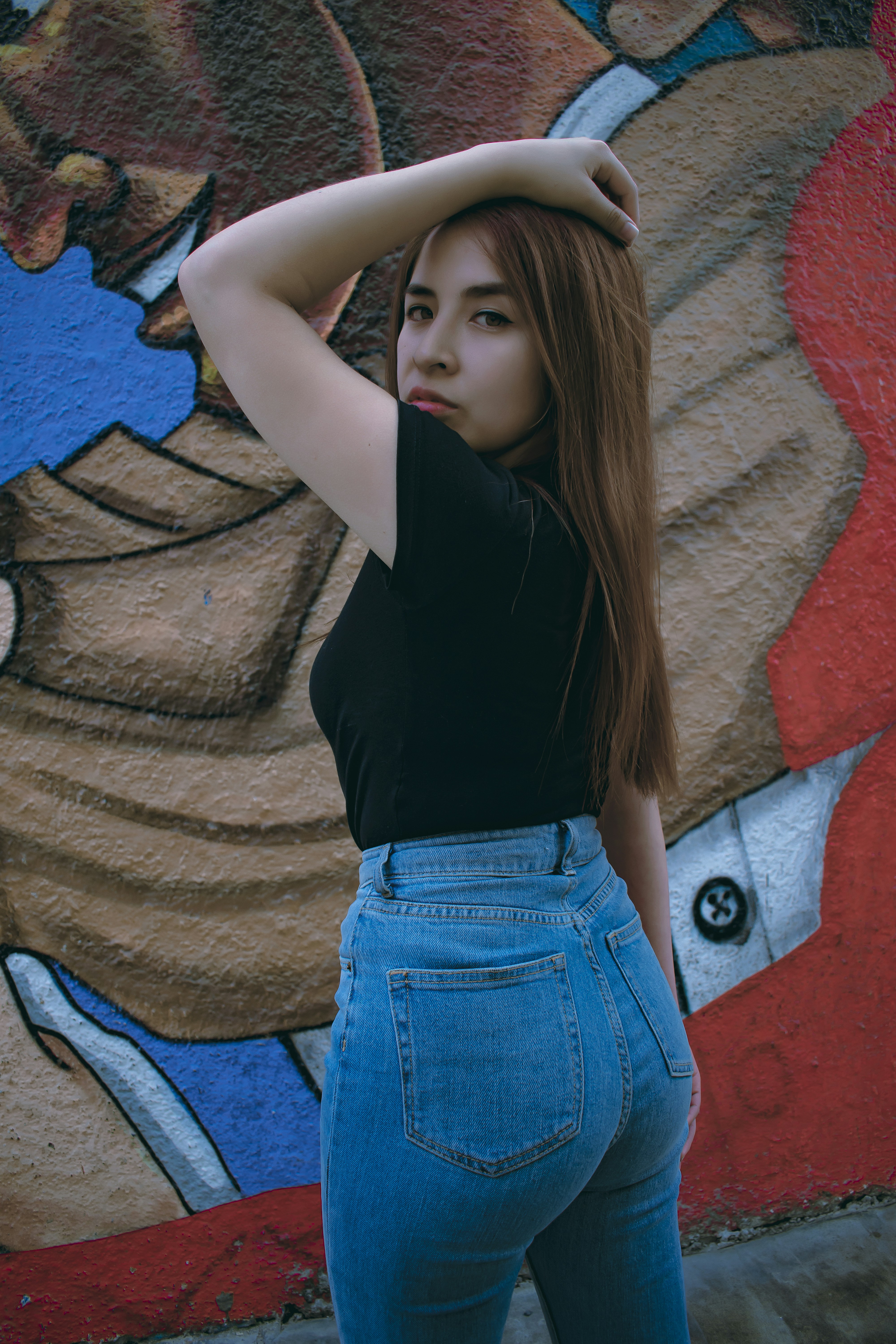 A woman with long hair standing in front of a wall photo – Free Girl ...