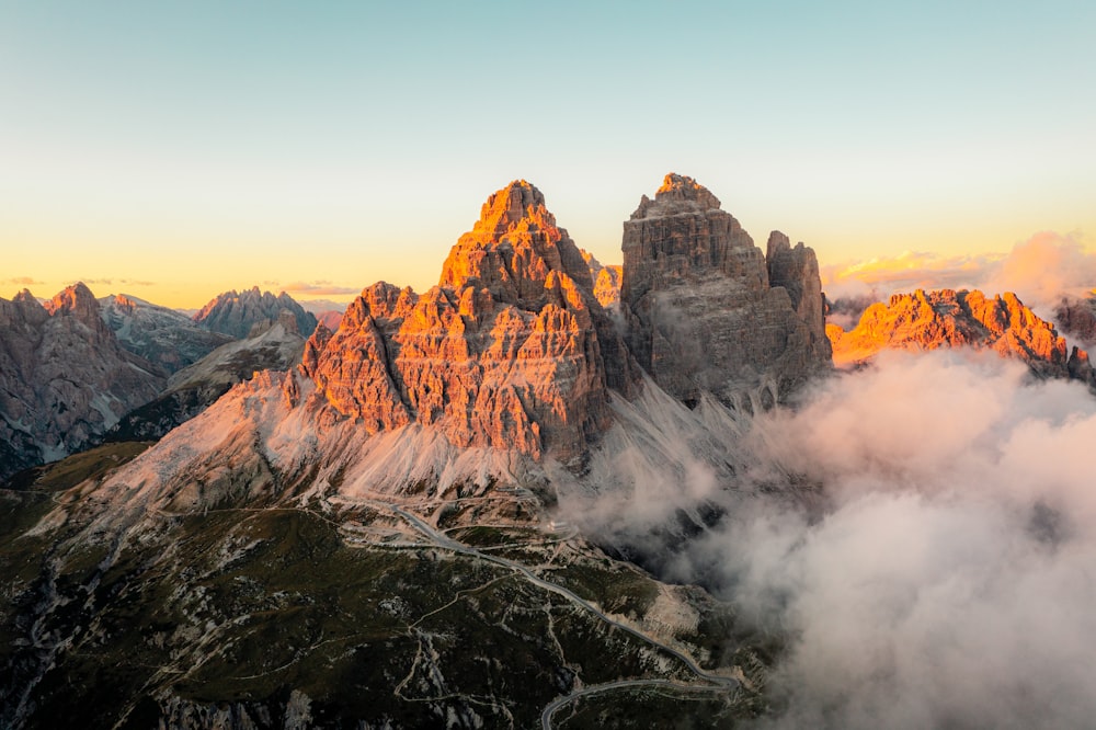 a group of mountain peaks surrounded by clouds