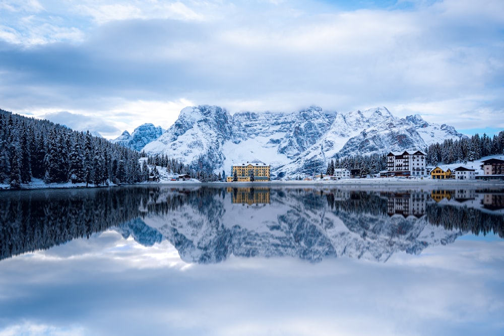 a mountain range is reflected in the still water of a lake