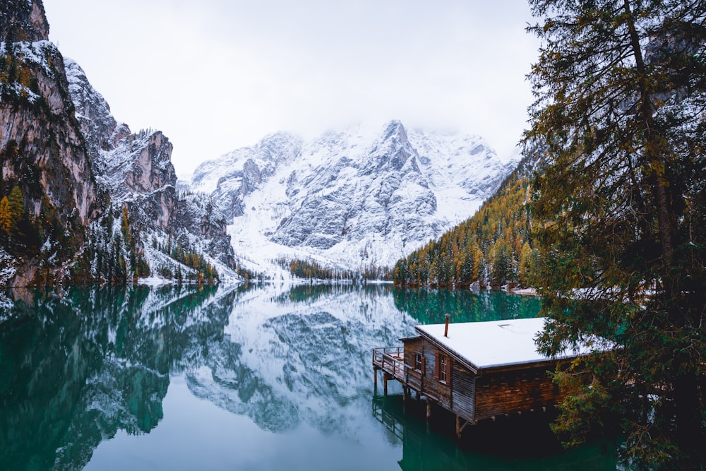 a lake surrounded by snow covered mountains and trees