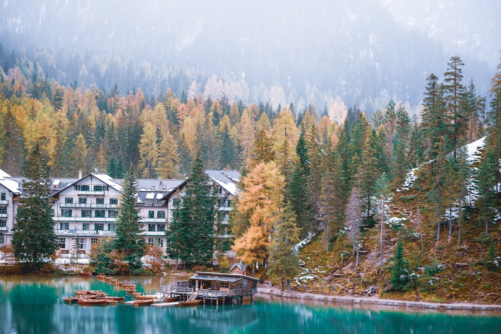 a lake surrounded by trees with a building in the background