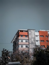 A clean, modern government building with a bright orange-yellow button in the foreground.