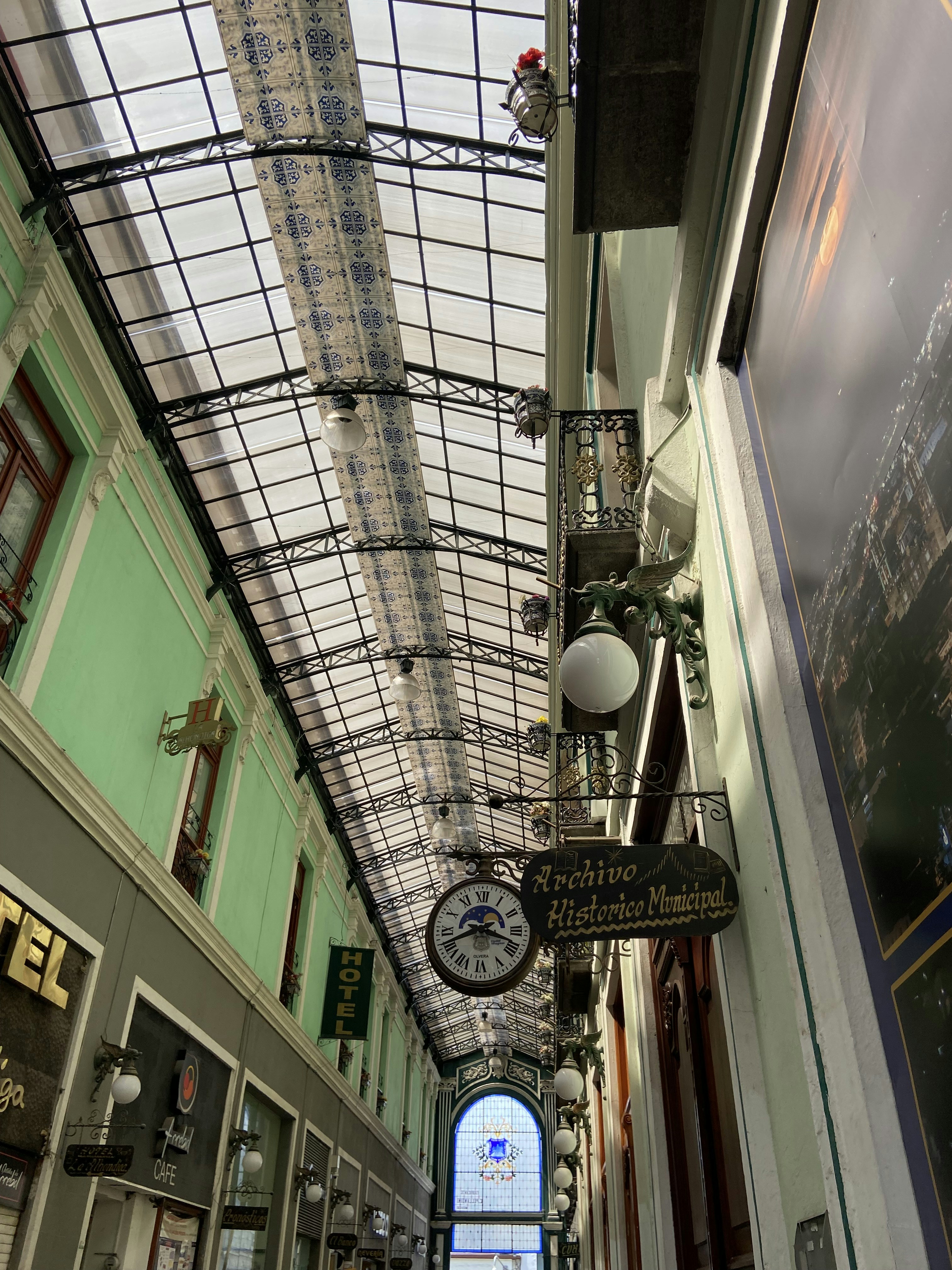 a clock hanging from the ceiling of a building
