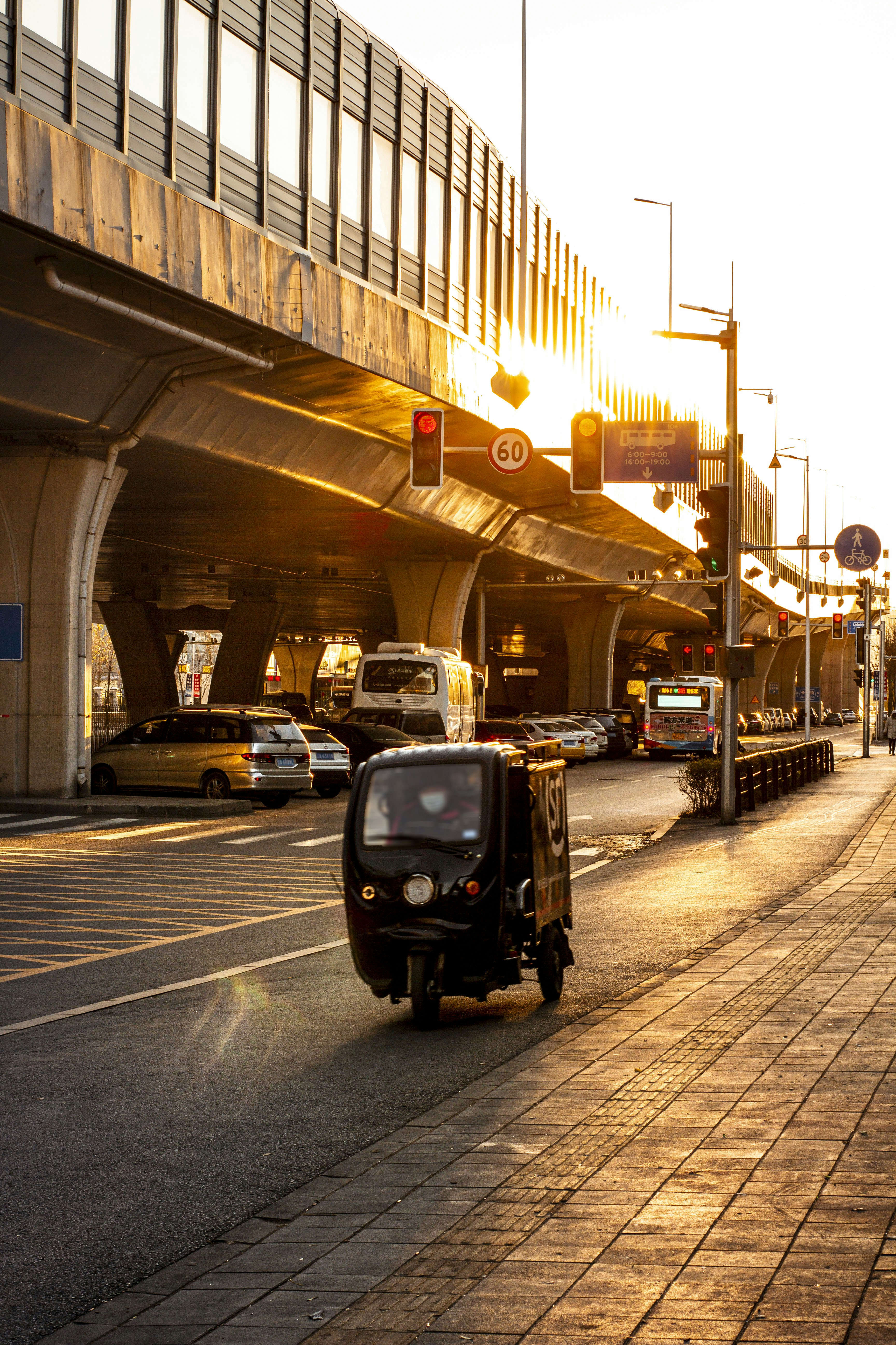 a scooter driving down a street next to a bridge