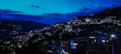 a night time view of a city on a hill