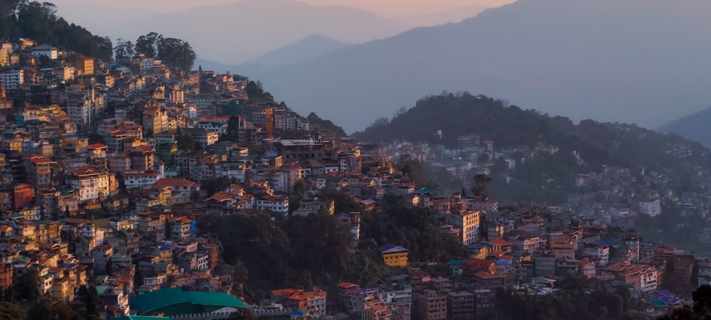 a city on top of a hill surrounded by mountains