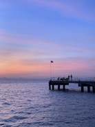 A sturdy dock extending into a calm Alaskan bay at sunset.