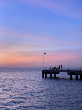A sturdy dock extending into a calm Alaskan bay at sunset.