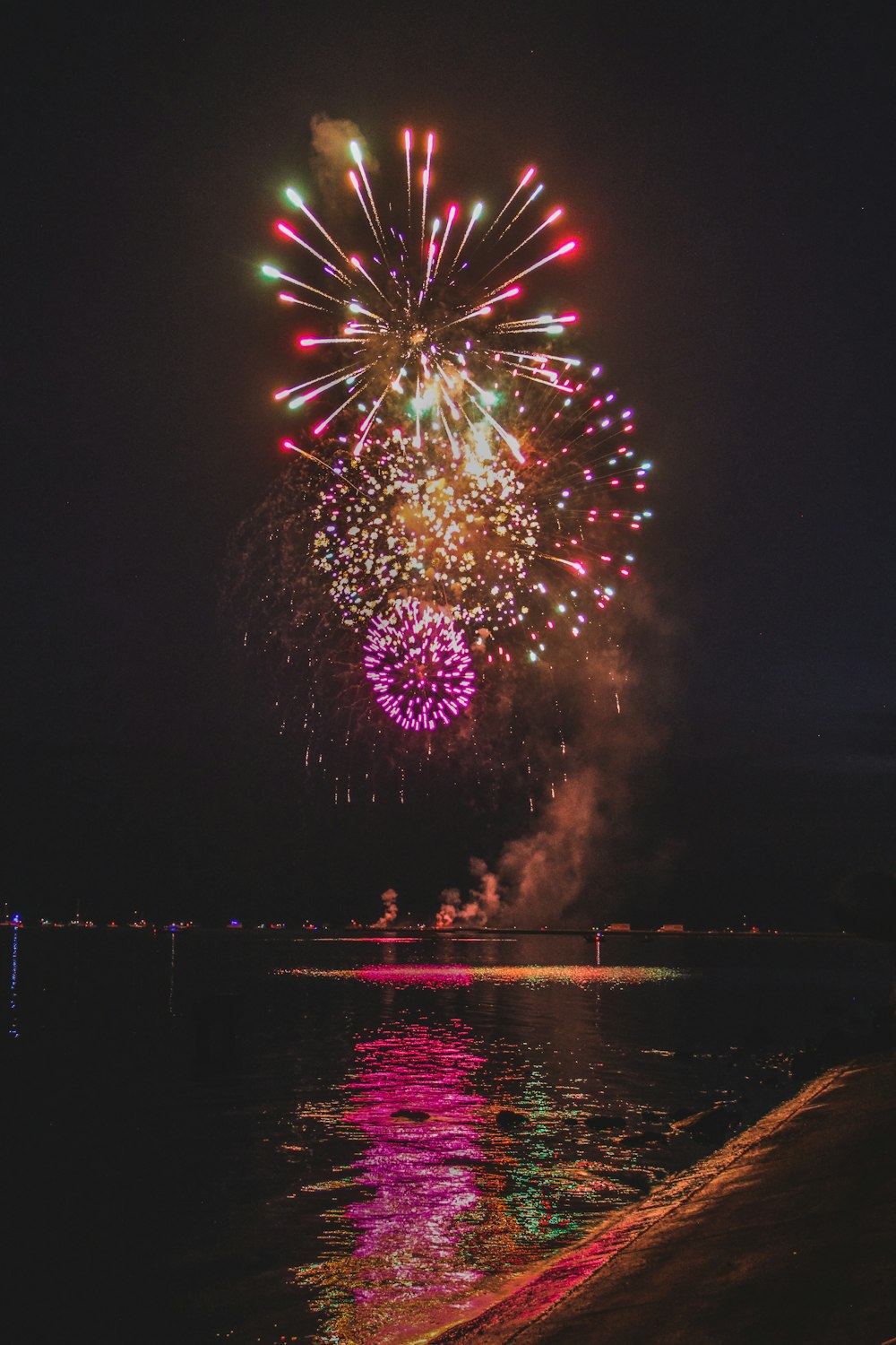 Ein farbenfrohes Feuerwerk über einem Gewässer