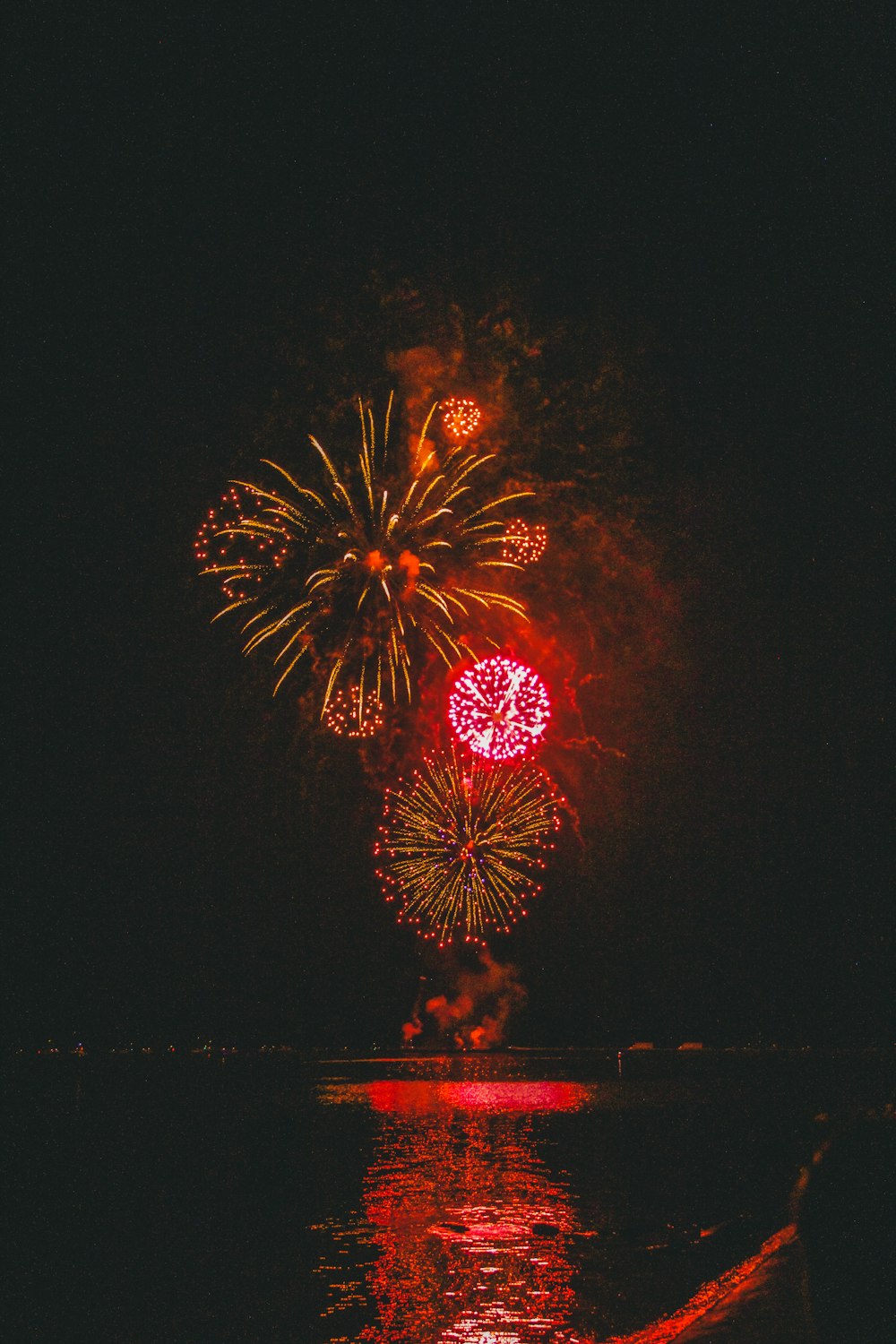 a firework display in the night sky over a body of water