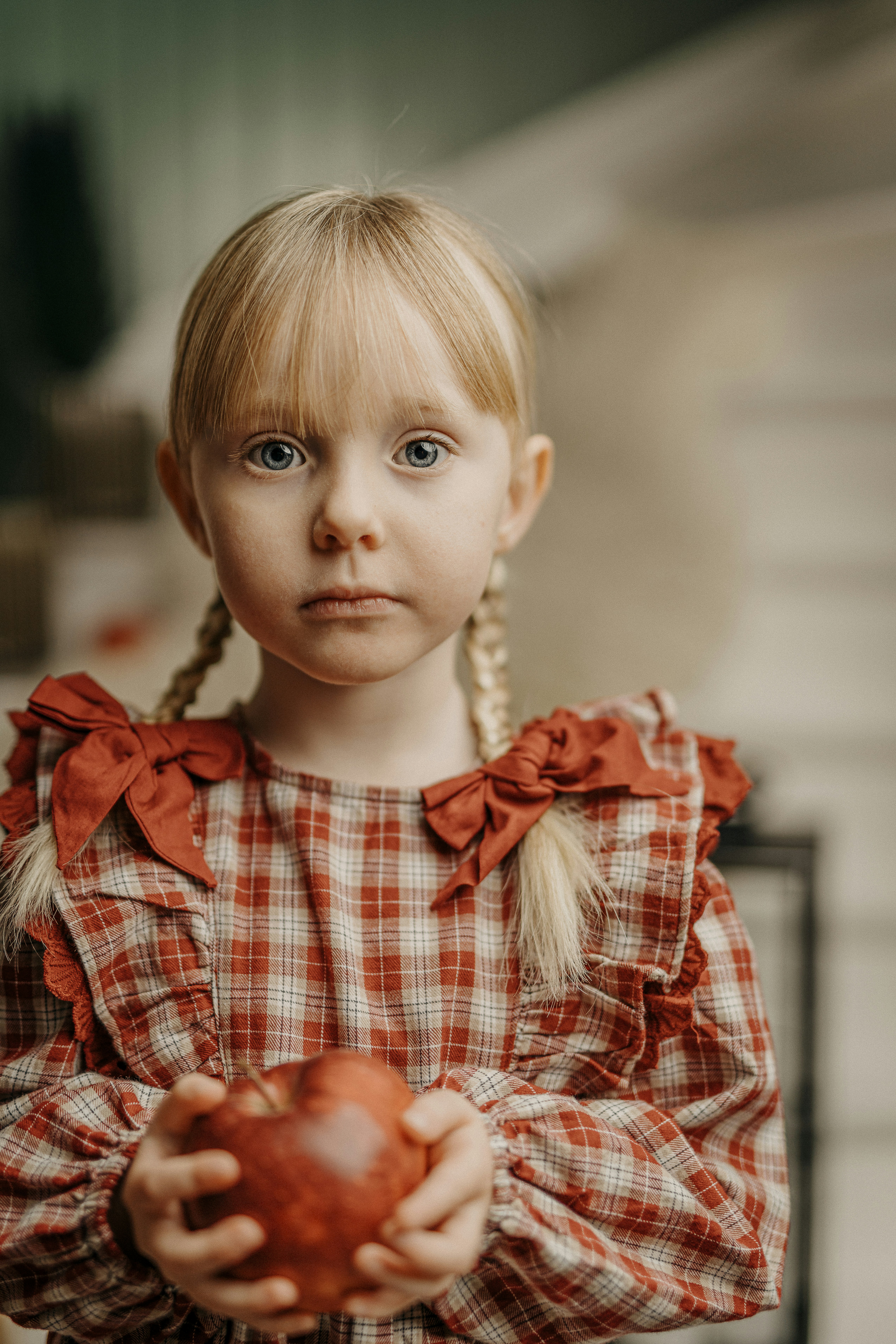 Une petite fille tenant une pomme avec un regard triste sur son visage photo – Photo Carte de 