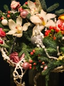 Festive bouquet featuring deep green fir branches, bright red berries, and soft white blooms.