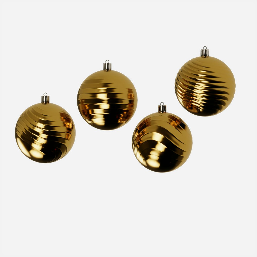 three shiny gold ornaments on a white background