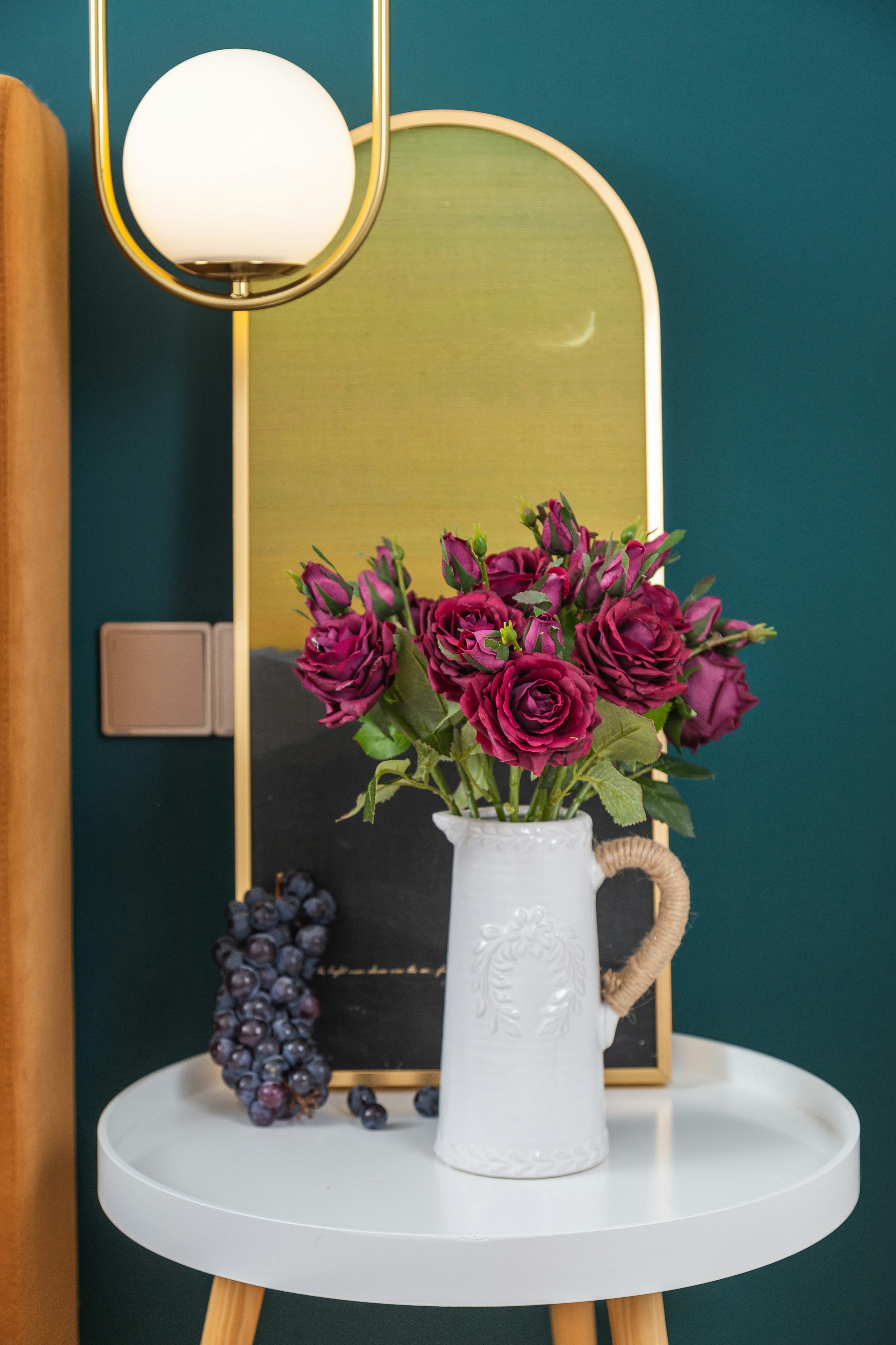a vase of flowers sitting on a table next to a mirror