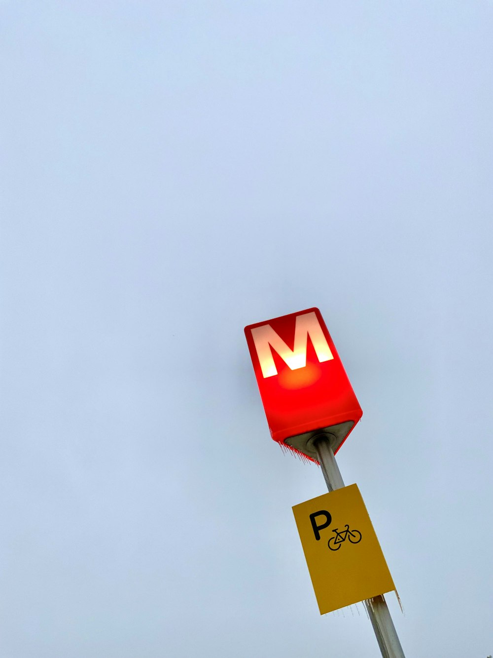 a mcdonald's sign with a bicycle sign below it