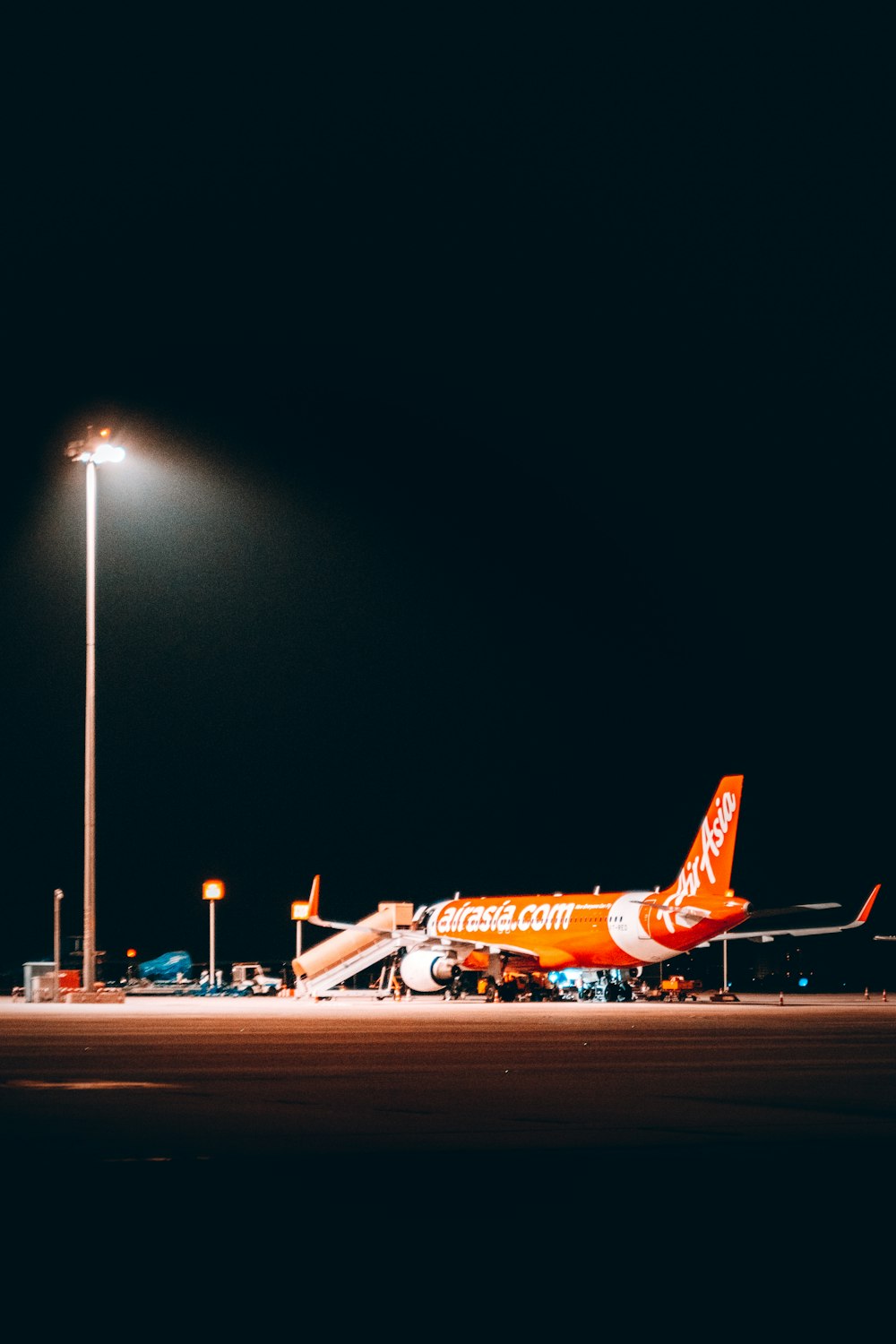 an orange and white airplane parked at an airport