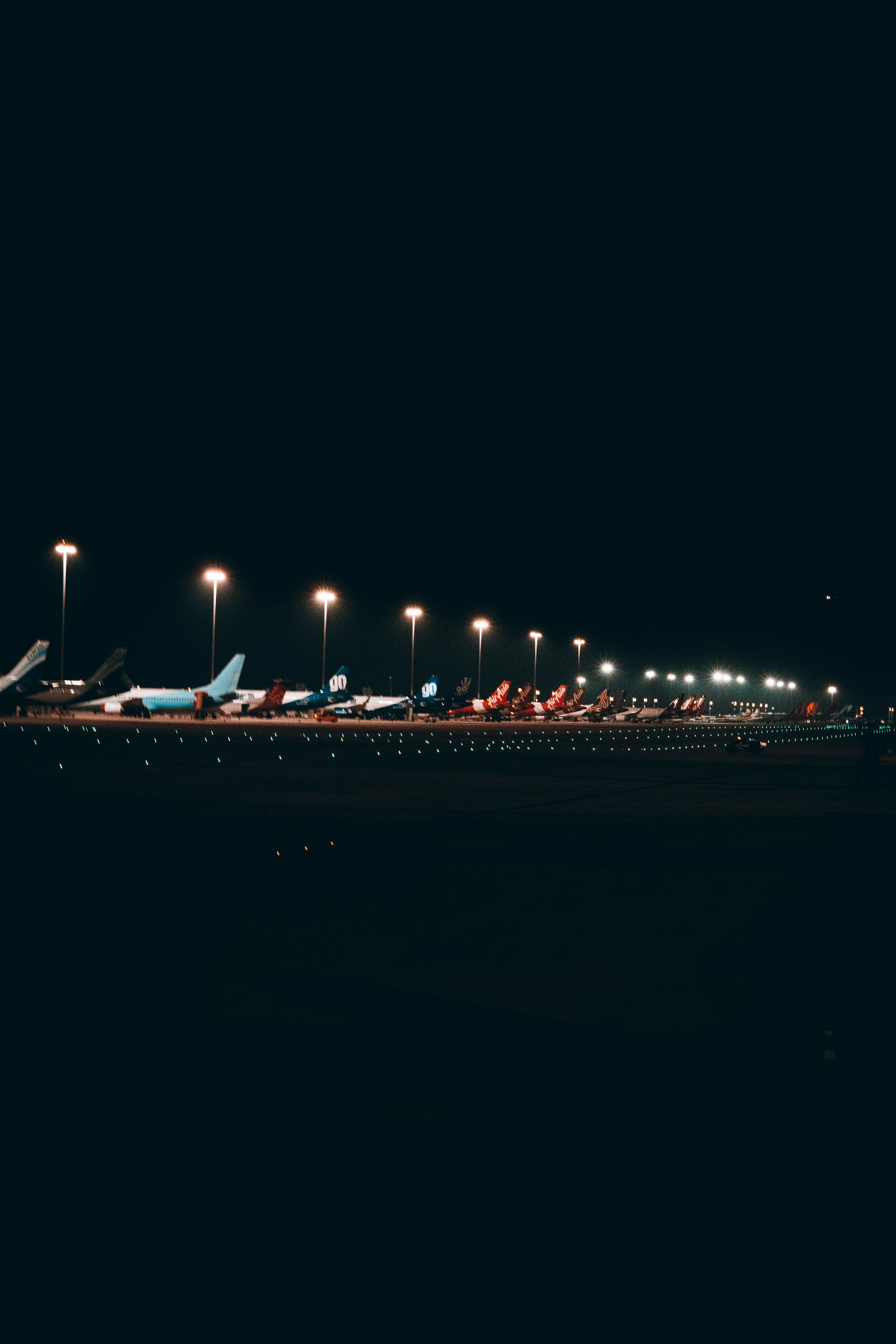 a row of airplanes sitting on top of an airport tarmac