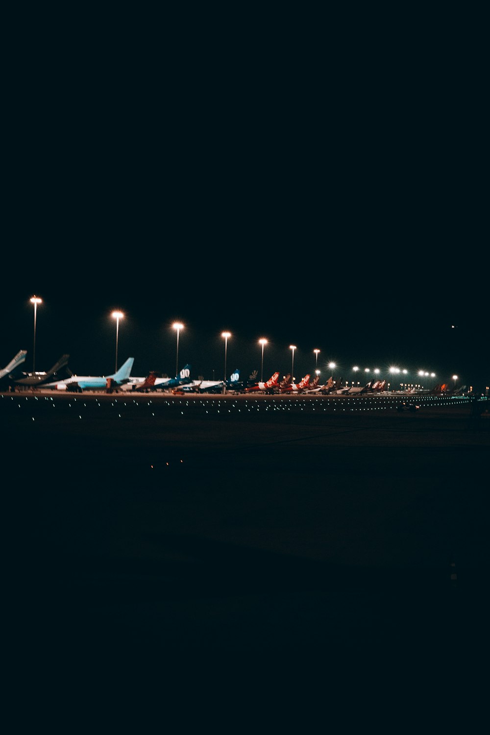 a row of airplanes sitting on top of an airport tarmac