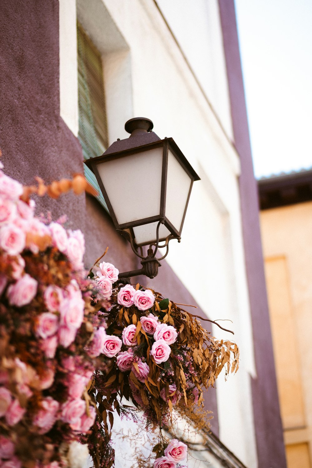 a lamp post with a bunch of flowers hanging from it