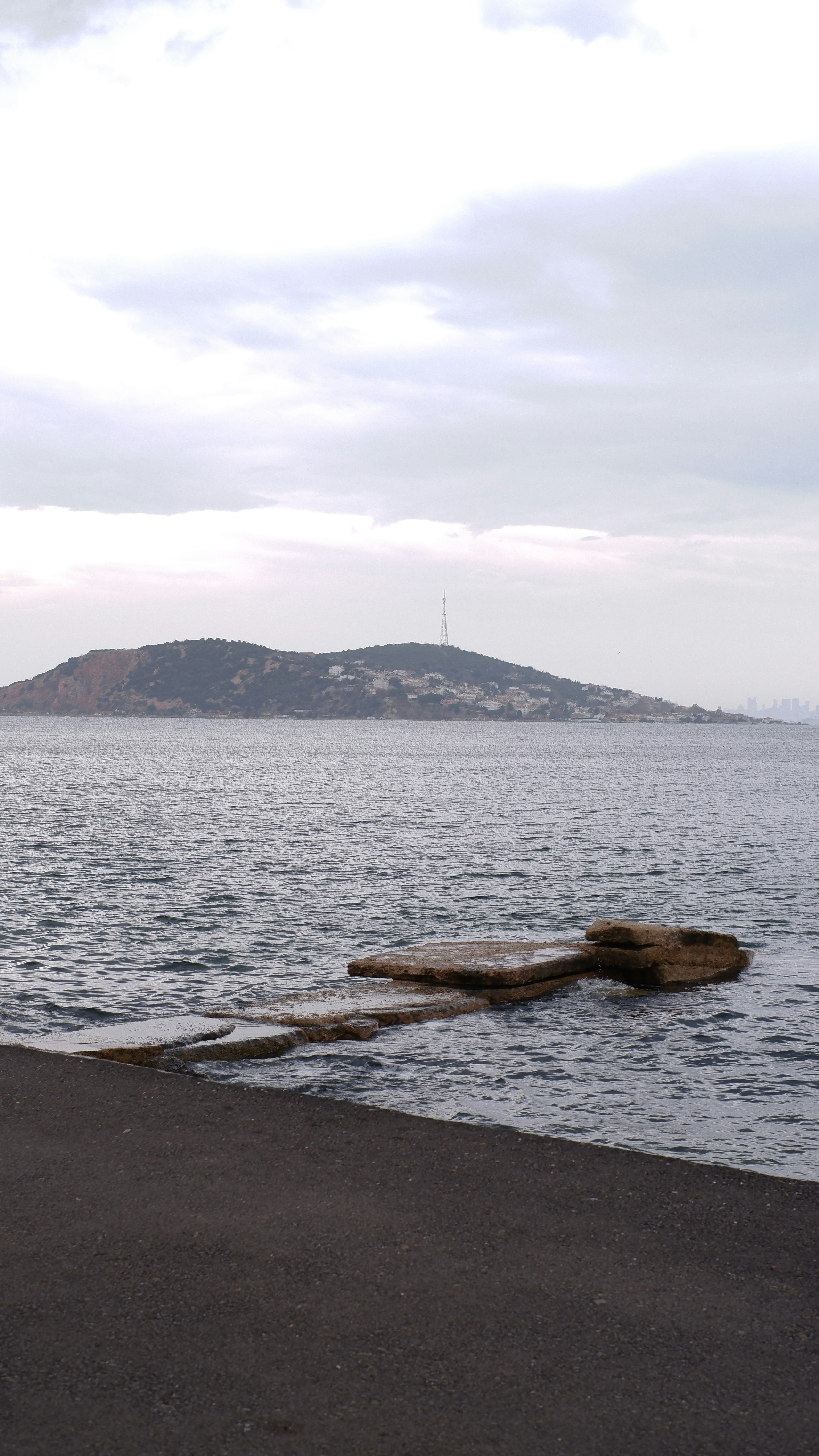 a body of water with a hill in the background