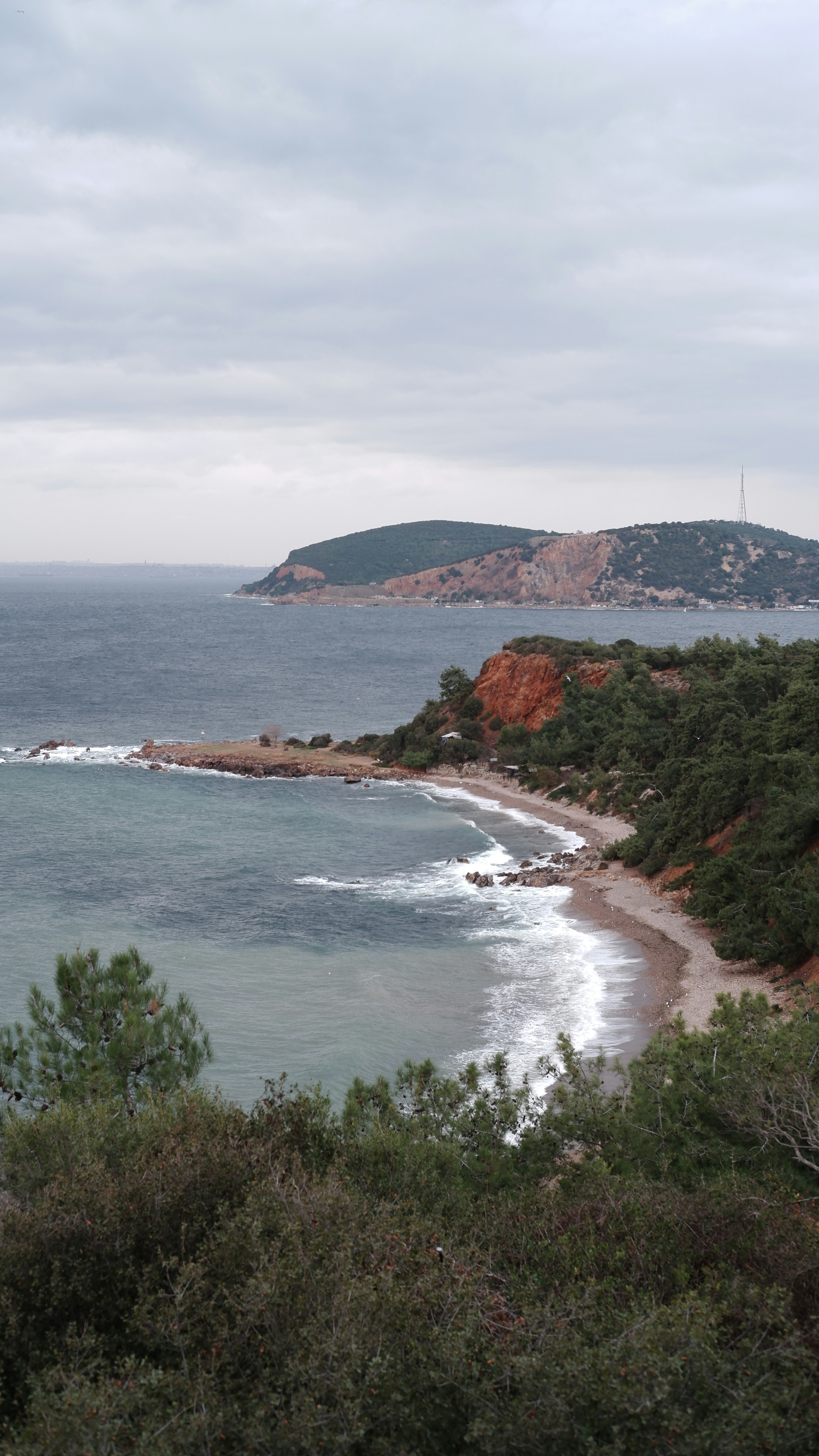 a body of water with a hill in the background
