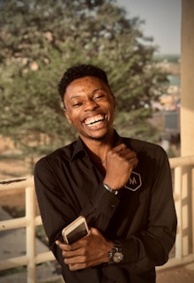 A happy customer holding an unlocked phone outdoors.