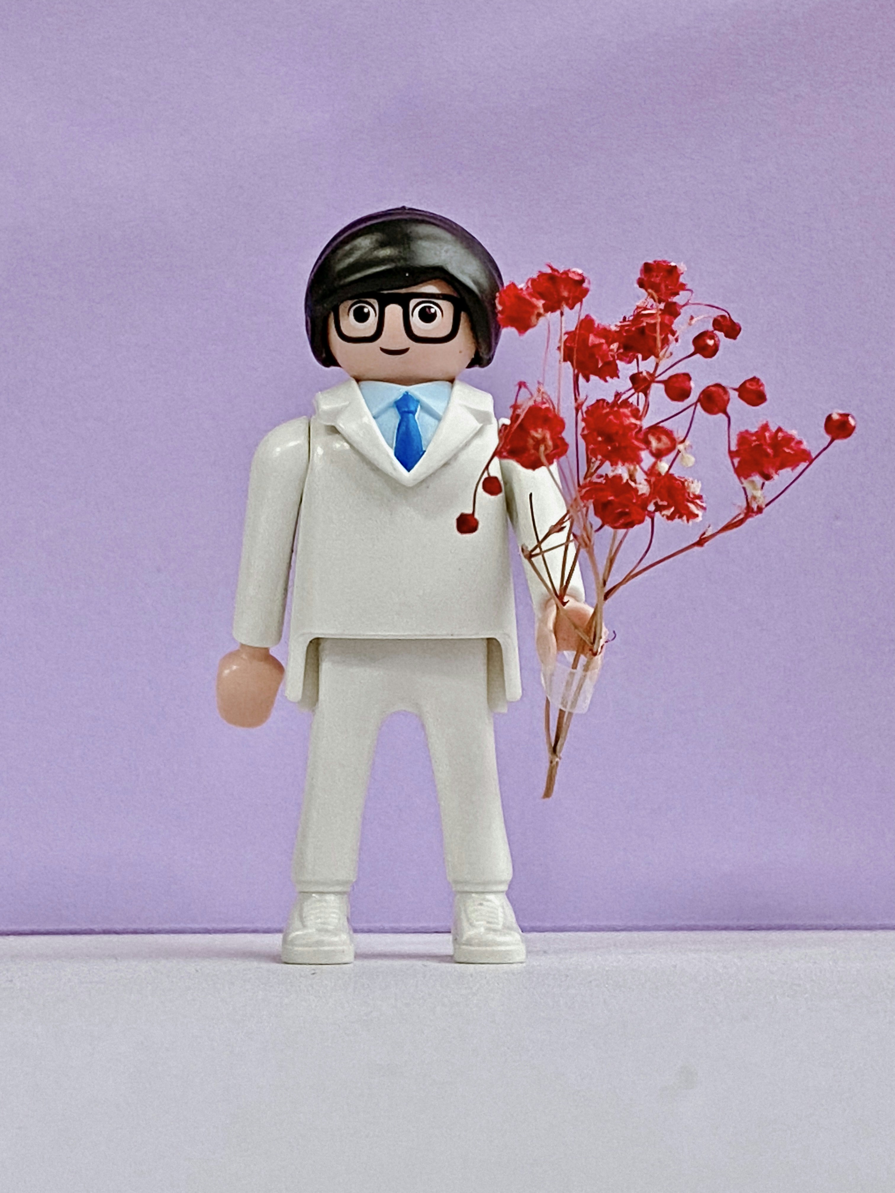 eine Spielzeugfigur mit einem Strauß roter Blumen