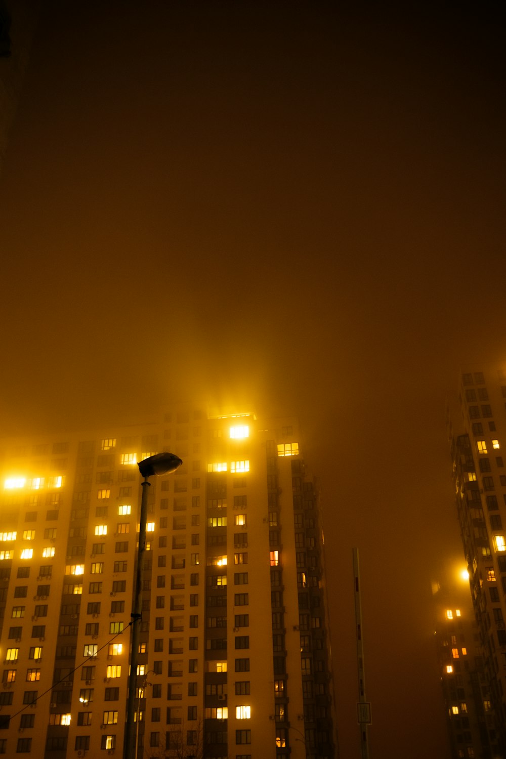 a foggy night in a city with tall buildings