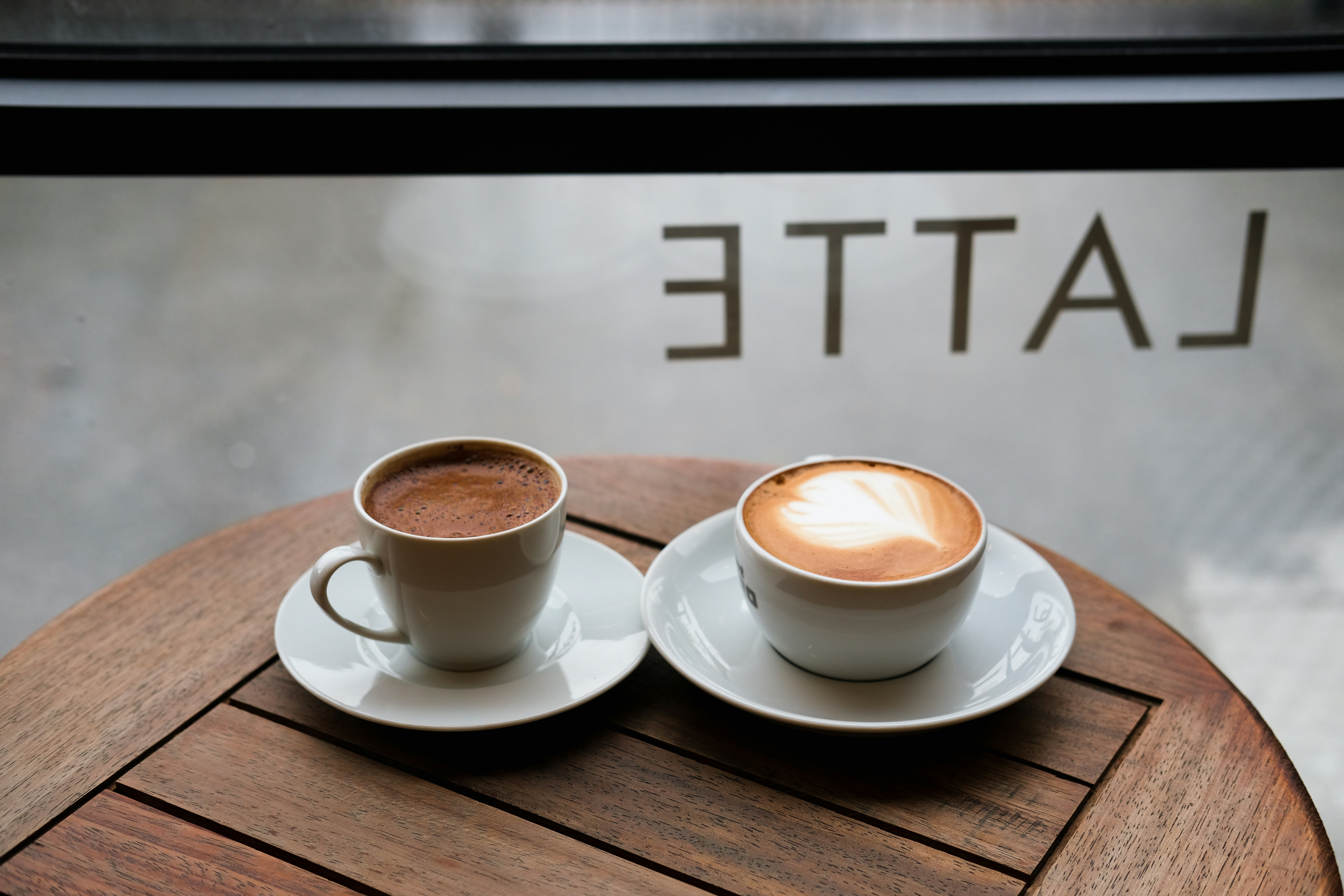 Two cups of coffee on cafe table with natural light streaming through window