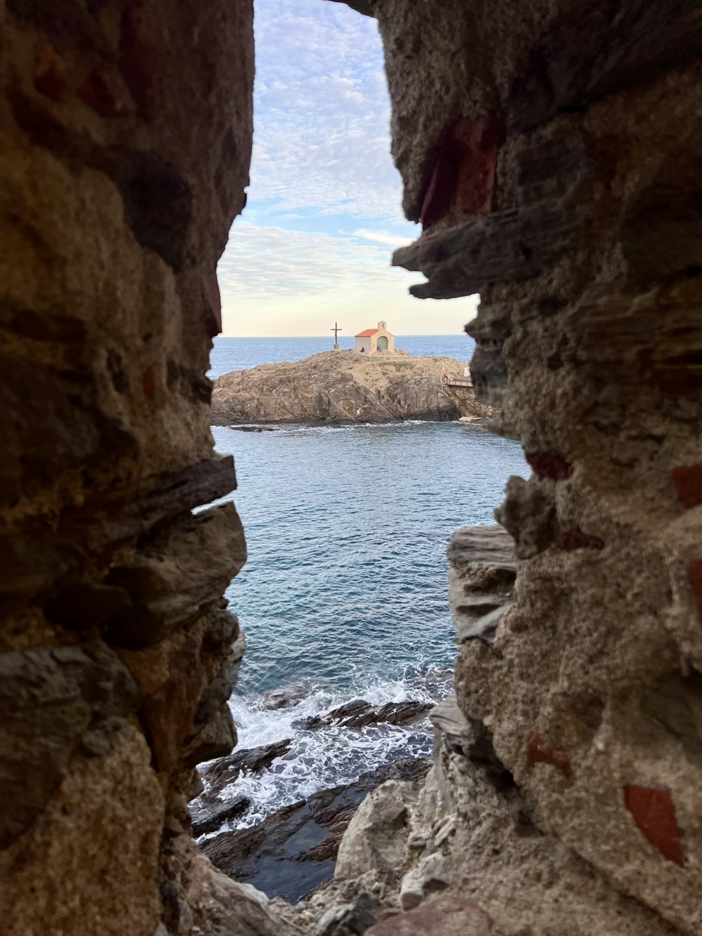 a view of a body of water through some rocks