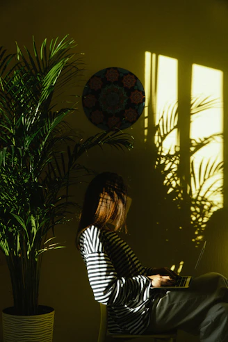 a woman sitting in a chair with a laptop
