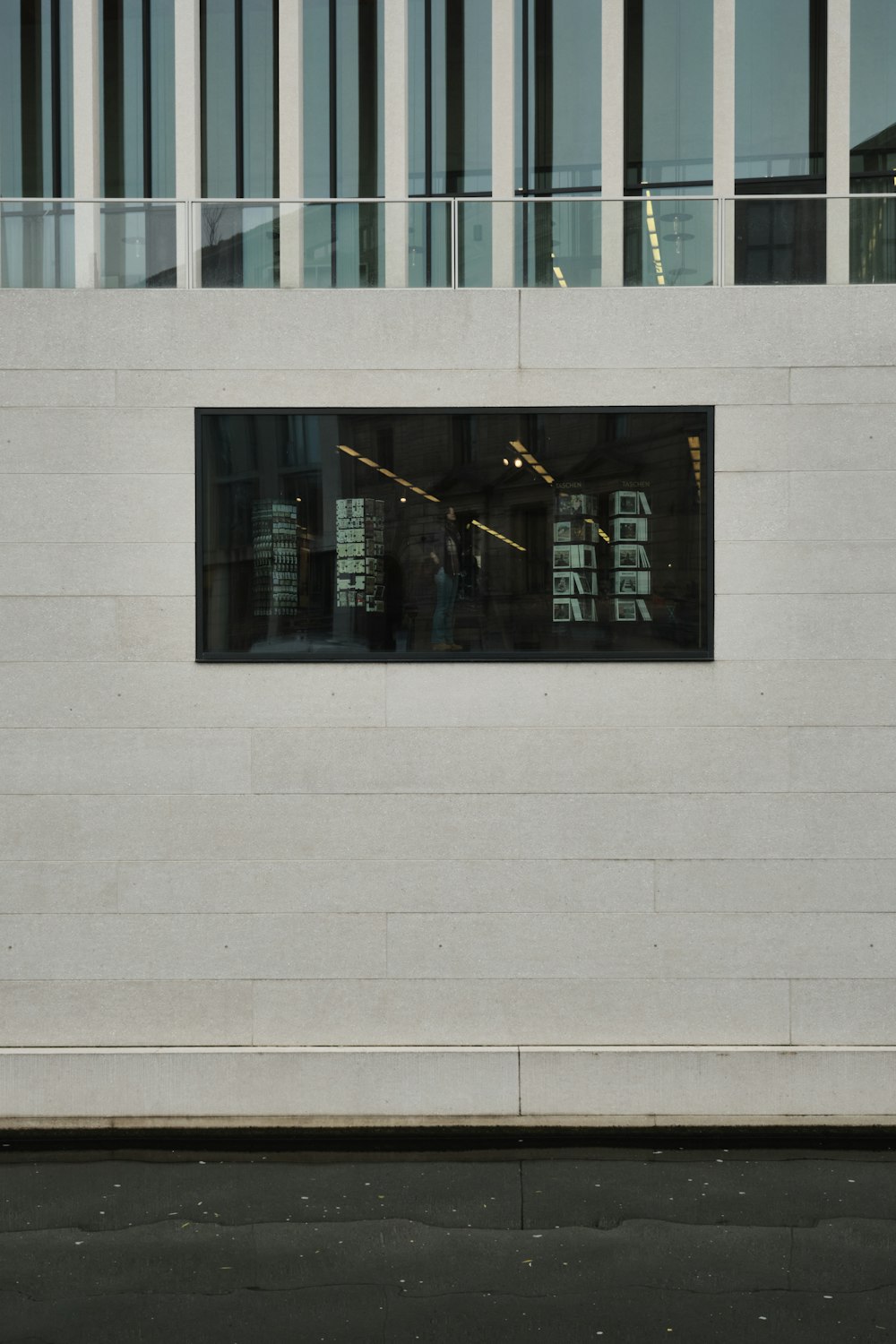 a man walking down a street past a tall building