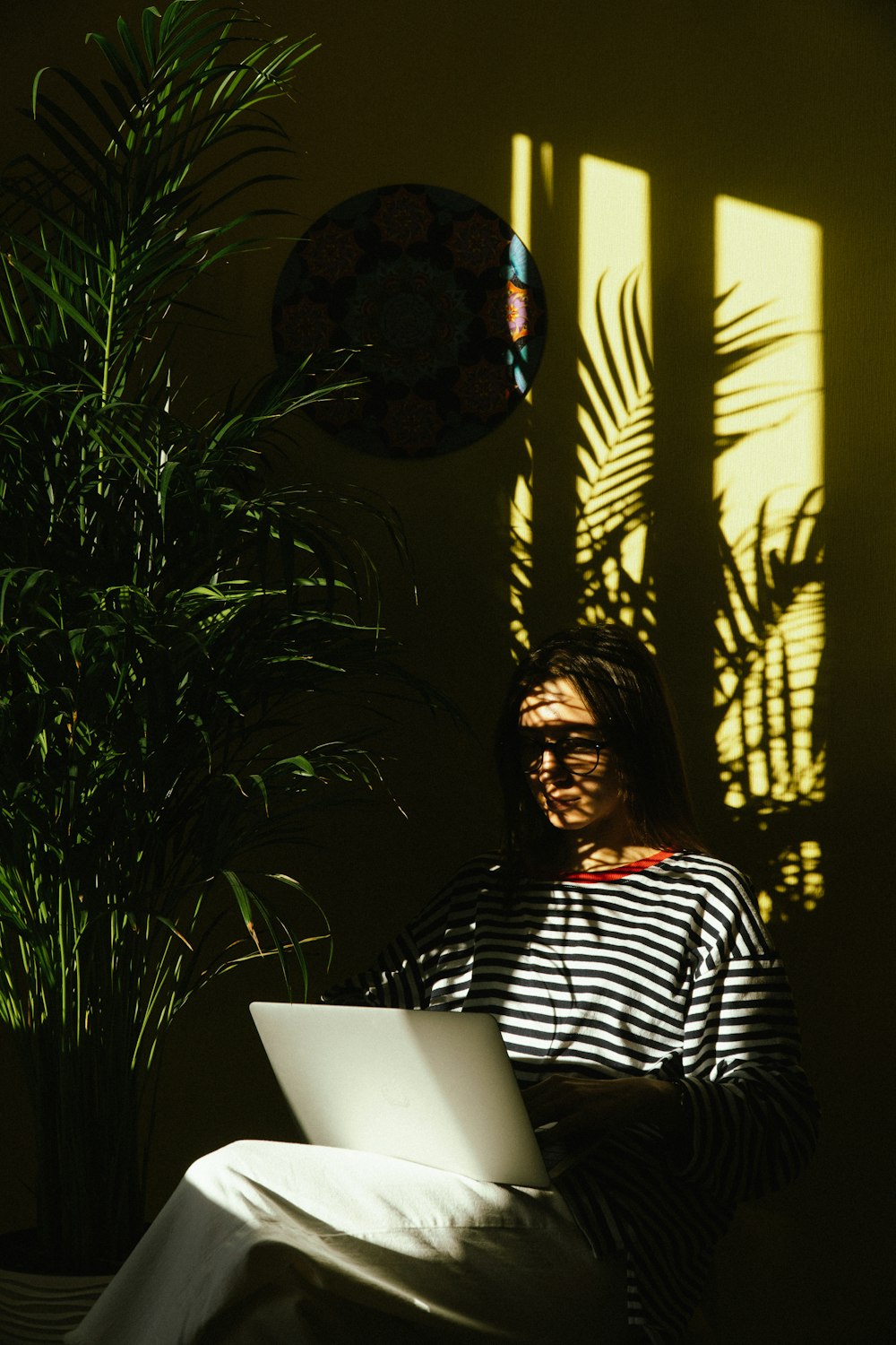 a woman sitting in a chair using a laptop computer