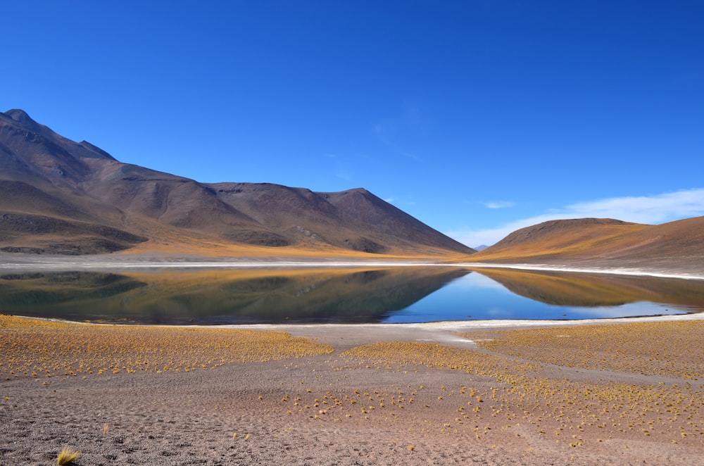 a lake surrounded by mountains in the desert