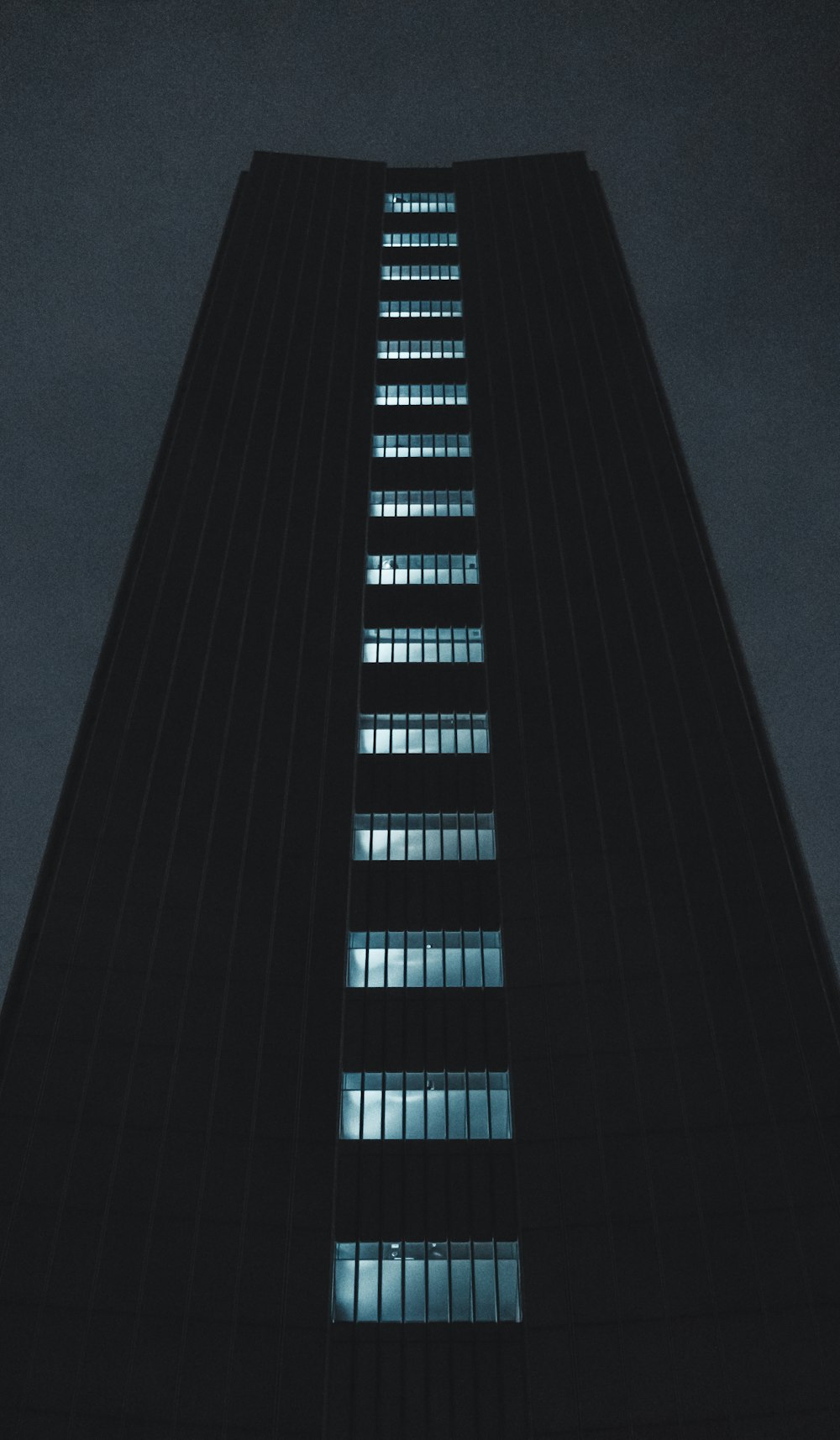 a tall building with many windows lit up at night