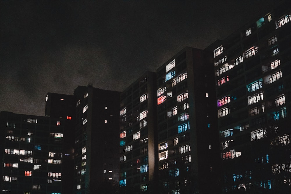 a group of tall buildings lit up at night