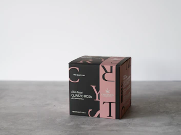 Elegant black and gold tea packaging displayed on a clean white surface with soft green accents