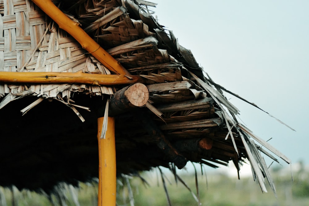 a close up of a straw hut with a clock on it