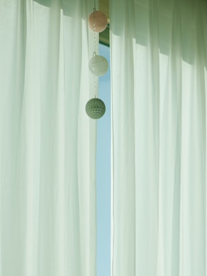 A stylish curtain rod holding warm-toned curtains in a minimalist setting.