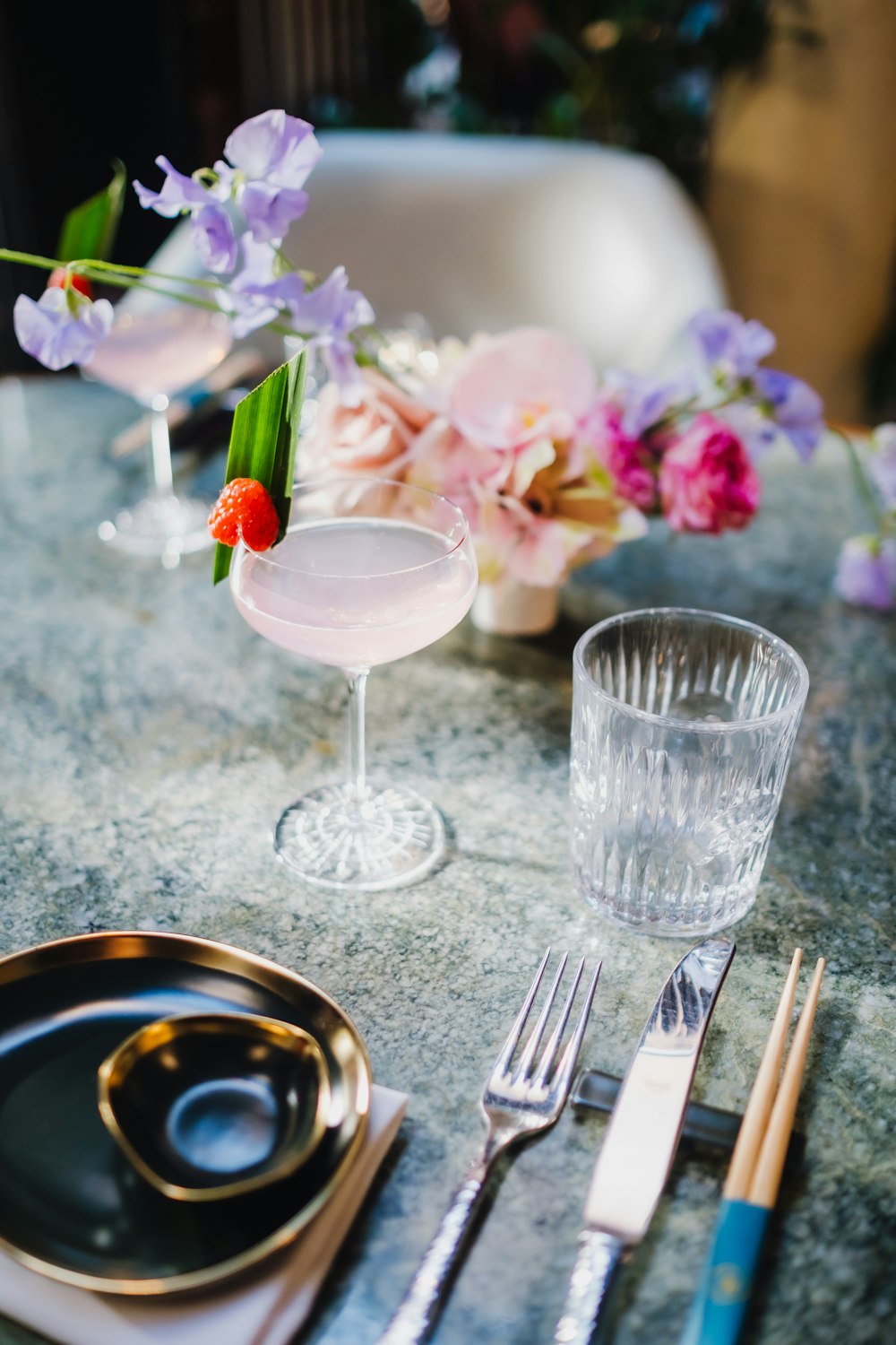 a table topped with a plate and a glass filled with liquid