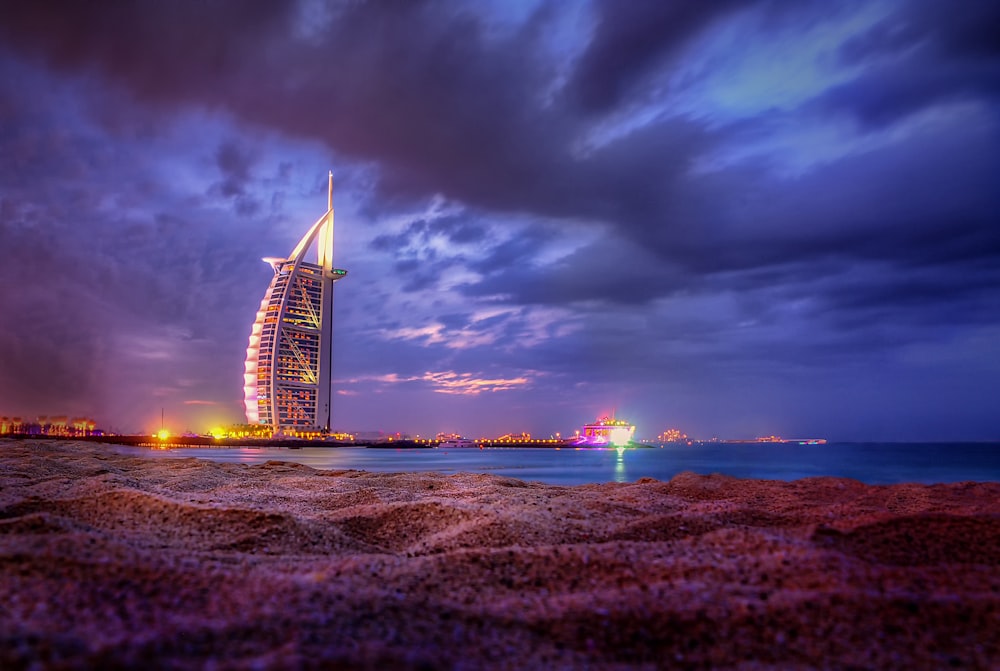 a tall building sitting on top of a beach next to the ocean