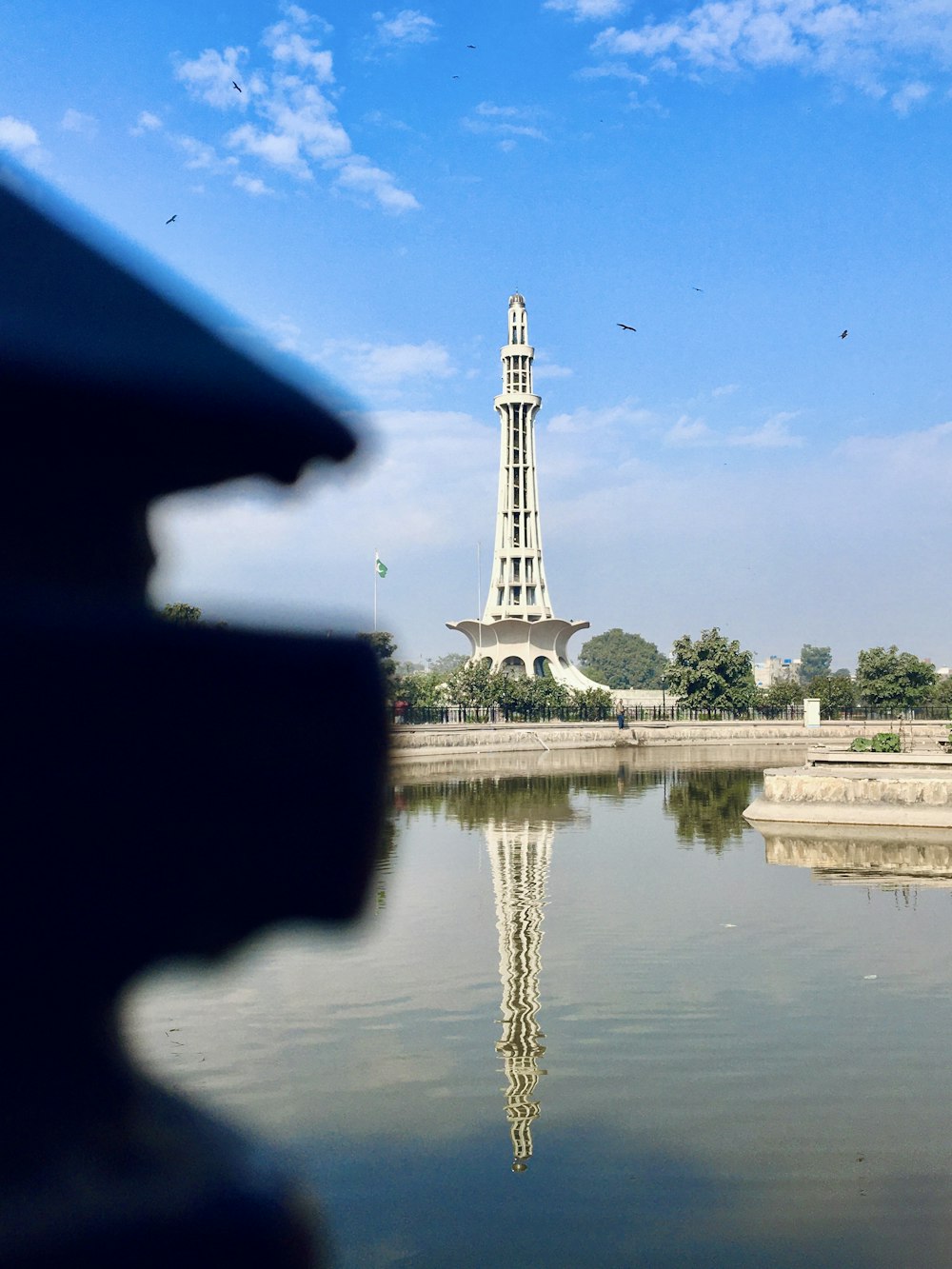 a tall white tower sitting next to a body of water