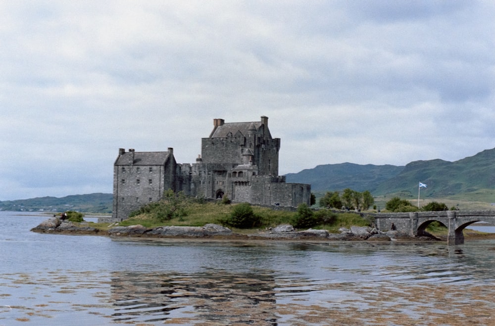 Foto Un castillo sentado en una pequeña isla en medio de un lago – Imagen  Edificio gratis en Unsplash