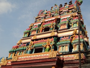 a very tall colorful building with statues on it's sides