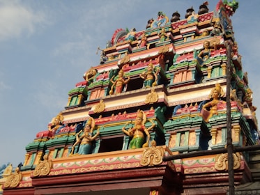 a very tall colorful building with statues on it's sides
