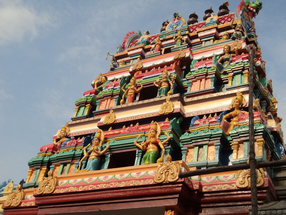 a very tall colorful building with statues on it's sides