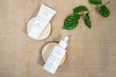 Scientist preparing natural supplements next to skincare products on a wooden table.